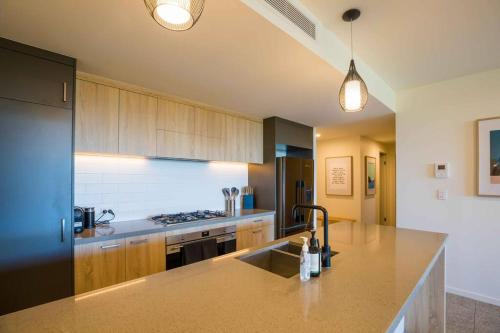 a kitchen with a sink and a stove top oven at The Beach Oasis ~ Dune in Kingscliff