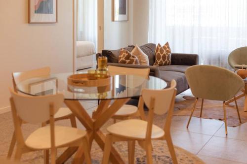 a living room with a glass table and chairs at The Beach Oasis ~ Dune in Kingscliff