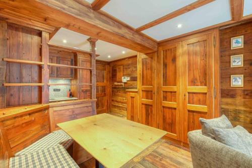 - une cuisine avec des murs en bois et une table dans une chambre dans l'établissement Chamonix centre, « Lucille »,balcon, vue imprenable et parking, à Chamonix-Mont-Blanc