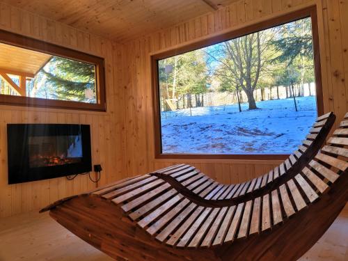 a wooden hammock in a log cabin with a fireplace at Rezidence Kouty in Loučná nad Desnou
