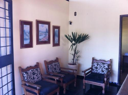 a room with two chairs and a potted plant at Cacique Hotel in Ribeirão Preto