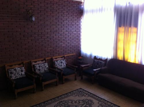 a living room with chairs and a couch and a brick wall at Cacique Hotel in Ribeirão Preto
