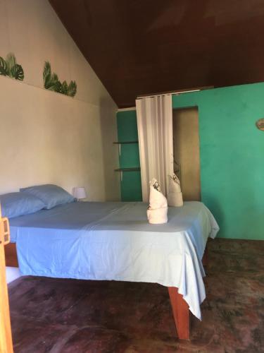 a bedroom with a bed with blue and green walls at CABINA EL MANU in Golfito