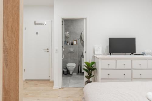 a white bedroom with a bathroom with a toilet at Classy & Cozy apartment 2 in Ljubljana