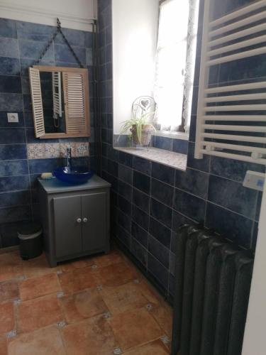 a bathroom with a sink and a blue tiled wall at Gîte 4 pers proche cure thermale, Futuroscope, calme et nature à La Roche Posay in La Roche-Posay