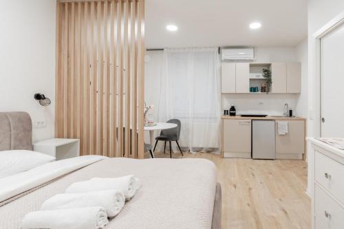 a white room with two beds and a kitchen at Classy & Cozy apartment 2 in Ljubljana