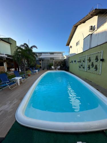a large blue swimming pool next to a building at Serra Negra Pousada Spa in Guarapari