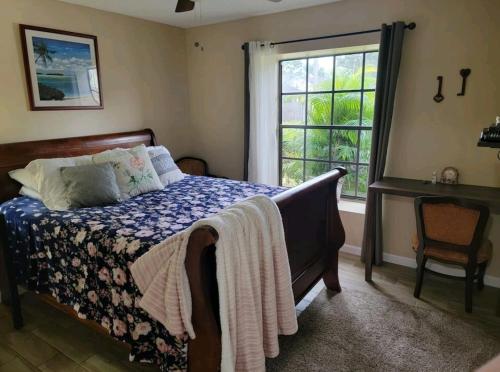 Schlafzimmer mit einem Bett und einem Fenster in der Unterkunft Harmony Bed and Breakfast Private Queen GardenviewRoom in Lutz