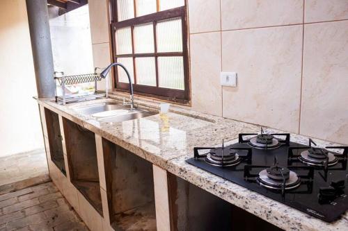 eine Küche mit Herd und Spüle in der Unterkunft Casa Pedra & Mar - Paraiso na Praia de Caieiras in Guaratuba