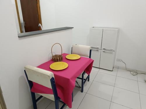una mesa rosa con dos placas amarillas. en Apartamento Quarto e Cozinha cod 4 Tremembe, en São Paulo