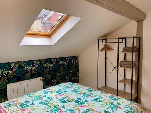 a bedroom with a bed and a skylight at le Seize B in Épernay