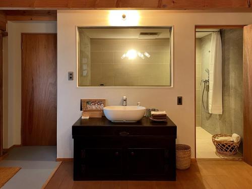a bathroom with a sink and a mirror and a shower at The Bath & Bed Obuse - Vacation STAY 15924 in Obuse