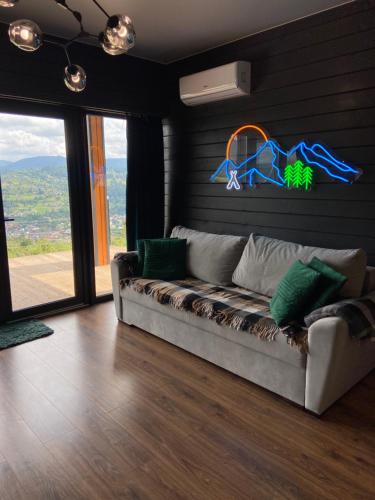 a living room with a couch in a room at Under Sky Slavske - Котеджі з Теплим басейном ,чаном-джакузі, панорамною ванною та PlayStation 5 in Slavske