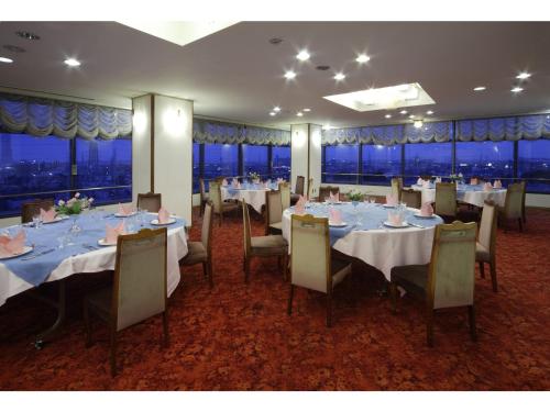 a dining room with tables and chairs with a view at Hotel New Yutaka - Vacation STAY 35266v in Izumi-Sano