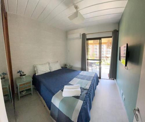 une chambre avec un lit bleu et un balcon dans l'établissement Angra dos Reis - Apartamentos com Vista para o mar OU para piscina Condomínio Porto Bali, à Angra dos Reis