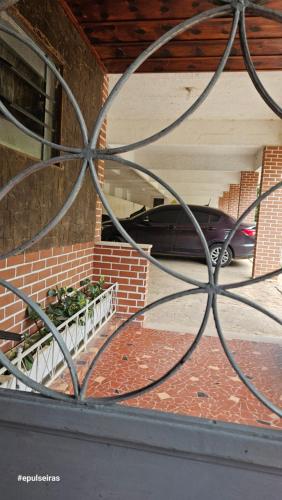 a car parked in a garage behind a metal fence at Apê210MiguelPereira in Miguel Pereira