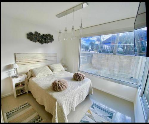 um quarto com uma cama e uma grande janela em Hermoso apto en Edificio Gala Puerto em Punta del Este