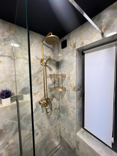 a bathroom with a shower with a blank sign on the wall at Under Sky Slavske - Котеджі з Теплим басейном ,чаном-джакузі, панорамною ванною та PlayStation 5 in Slavske