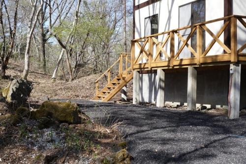 ein Haus mit einer Holzbrücke neben einem Gebäude in der Unterkunft Hoshi no Machi No, 177 - Vacation STAY 39992v in Tsumagoi