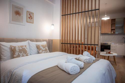 a bedroom with a bed with towels on it at White Luxury Apartments in Katerini
