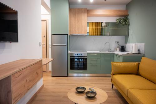 een keuken en een woonkamer met een bank en een tafel bij White Luxury Apartments in Kateríni