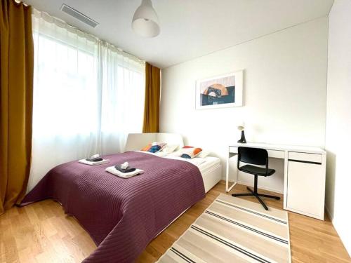 Schlafzimmer mit einem lila Bett und einem Schreibtisch in der Unterkunft Modern Urban Retreat in Pratteln