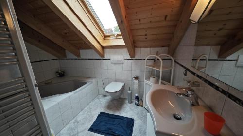 uma casa de banho com um lavatório, uma banheira e um WC. em Ferienhaus Weilheim mit Garten Spiel und Spass em Weilheim in Oberbayern