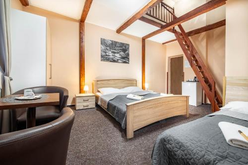 Přimda的住宿－LAGUNA Hotel & Restaurant，一间卧室配有一张床、一张桌子和一把椅子