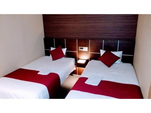 two beds in a hotel room with red pillows at My Hotel Okazaki - Vacation STAY 40801v in Okazaki