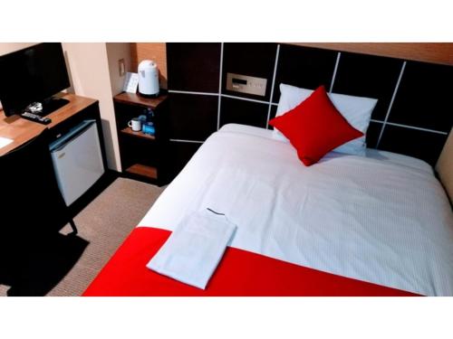 1 dormitorio con cama roja y blanca y almohada roja en My Hotel Okazaki - Vacation STAY 40791v, en Okazaki
