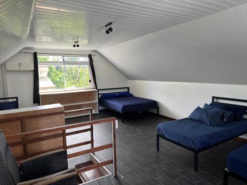 a room with two beds and a window at Maison Moehau Iti in Moorea