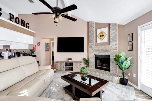 a living room with a white couch and a fireplace at Pong - A Birdy Vacation Rental in San Antonio