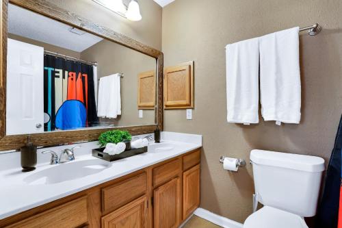 W łazience znajduje się umywalka, lustro i toaleta. w obiekcie Pong - A Birdy Vacation Rental w mieście San Antonio