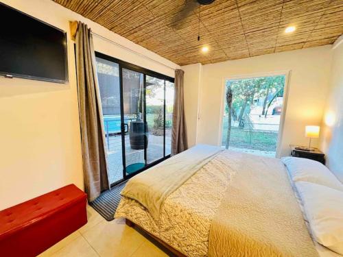 a bedroom with a large bed and a large window at Nirvana Beach Home in Paraíso