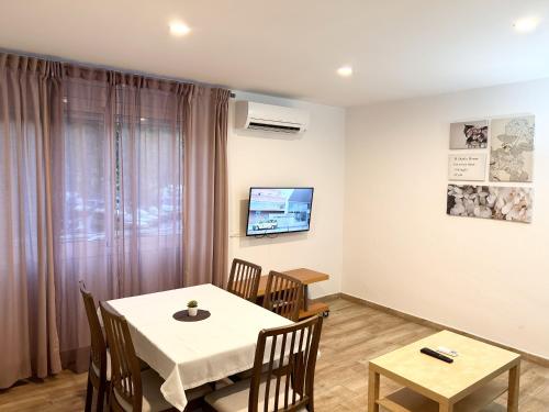 ein Esszimmer mit einem weißen Tisch und Stühlen in der Unterkunft Josep Tarradellas Entire Apartment in Sabadell