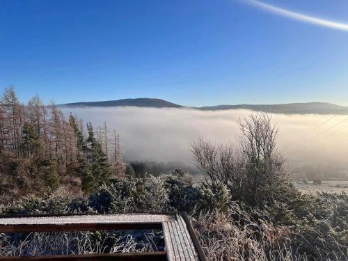 a view of a foggy field with trees and a hill at Daviot Luxury Pods in Inverness
