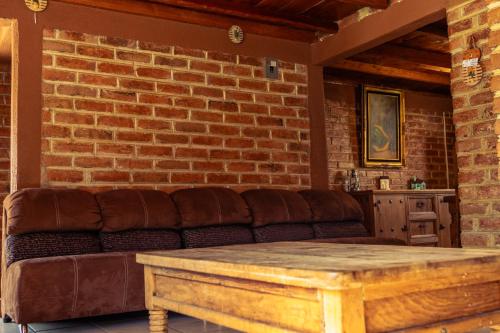 a living room with a couch and a brick wall at Hotel Real de San Antonio in Estanzuela