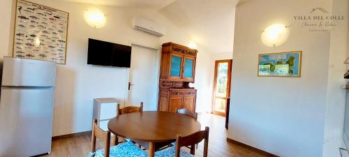 a dining room with a table and a refrigerator at Villa del Colle Charme e Relax in Procchio