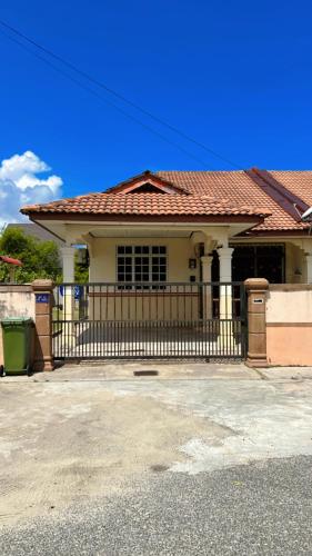 una casa con una valla delante de ella en AF Homestay Pantai Dungun, en Dungun