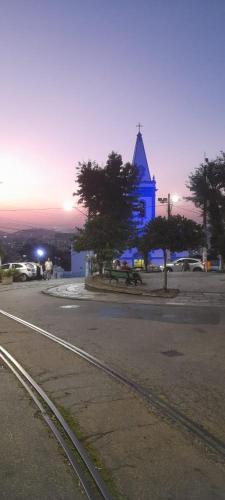 a church with a blue building in the background at Mimi House in Rio de Janeiro