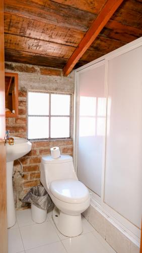 a bathroom with a toilet and a sink at Hotel Real de San Antonio in Estanzuela