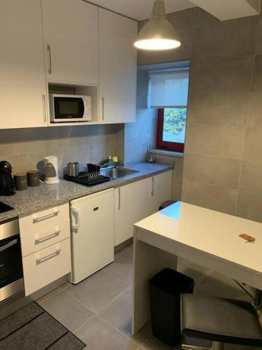 a kitchen with white cabinets and a sink at Casa da Carvalha - Loriga in Loriga