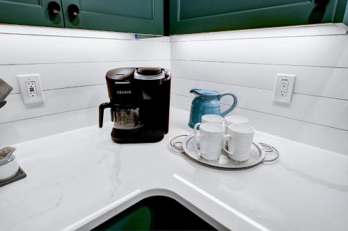 a counter with a coffee maker and cups on it at Richters Retreat - A birdy Vacation Rental in Boerne