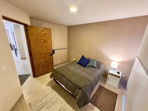 - une chambre avec un lit doté d'un oreiller bleu dans l'établissement Increíble Apartamento Querétaro, à Querétaro