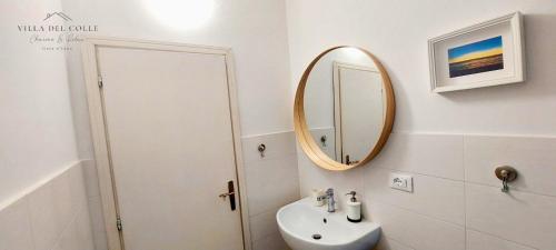 a white bathroom with a sink and a mirror at Villa del Colle Charme e Relax in Procchio