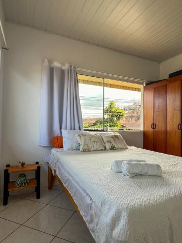 a bedroom with a bed and a large window at Espaço caraguatá in Florianópolis