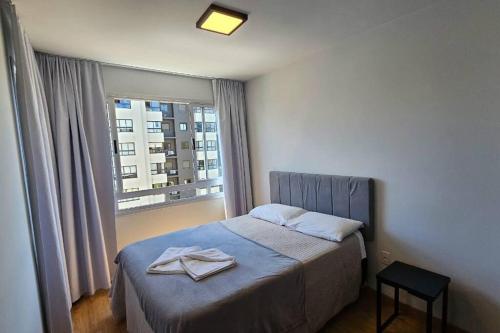 um quarto com uma cama com duas toalhas em Apartamento moderno em excelente localização em Bento Gonçalves