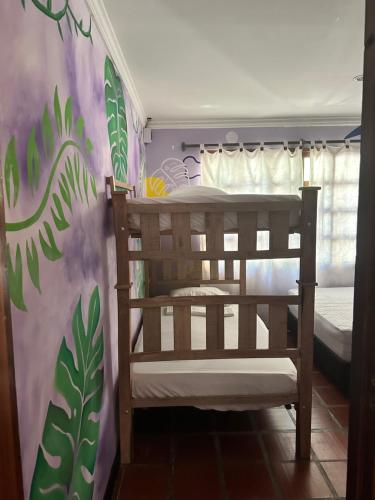 Hostal Casa Macondo في سانتا مارتا: سرير بطابقين في غرفة مع لوحة جدارية