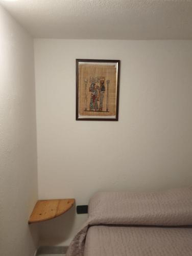 a bedroom with a bed and a picture on the wall at casa vacanze cettina home 3 mt 50 dal mare in Terra Mala