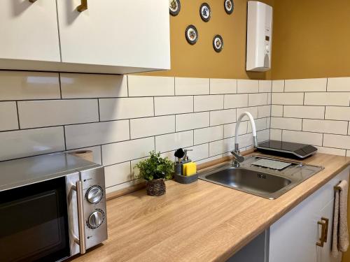a kitchen with a sink and a counter top at Terracotta Apartment - Zentral, Parken, Netflix, Kontaktloses Einchecken, Kingsize-Bett in Wuppertal